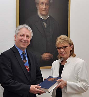 Rektor Prof. Bernhard Eitel mit Dr. Dagmar Drüll-Zimmermann bei der Übergabe des Gelehrtenlexikons